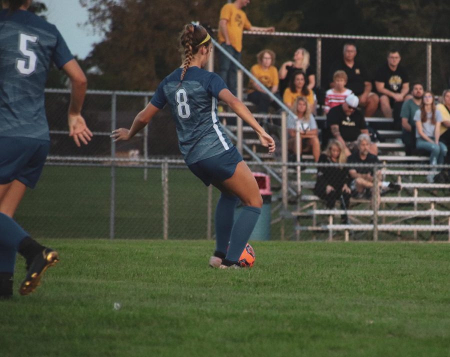 Taylor Cook, number 8, in action about to pass ball. 