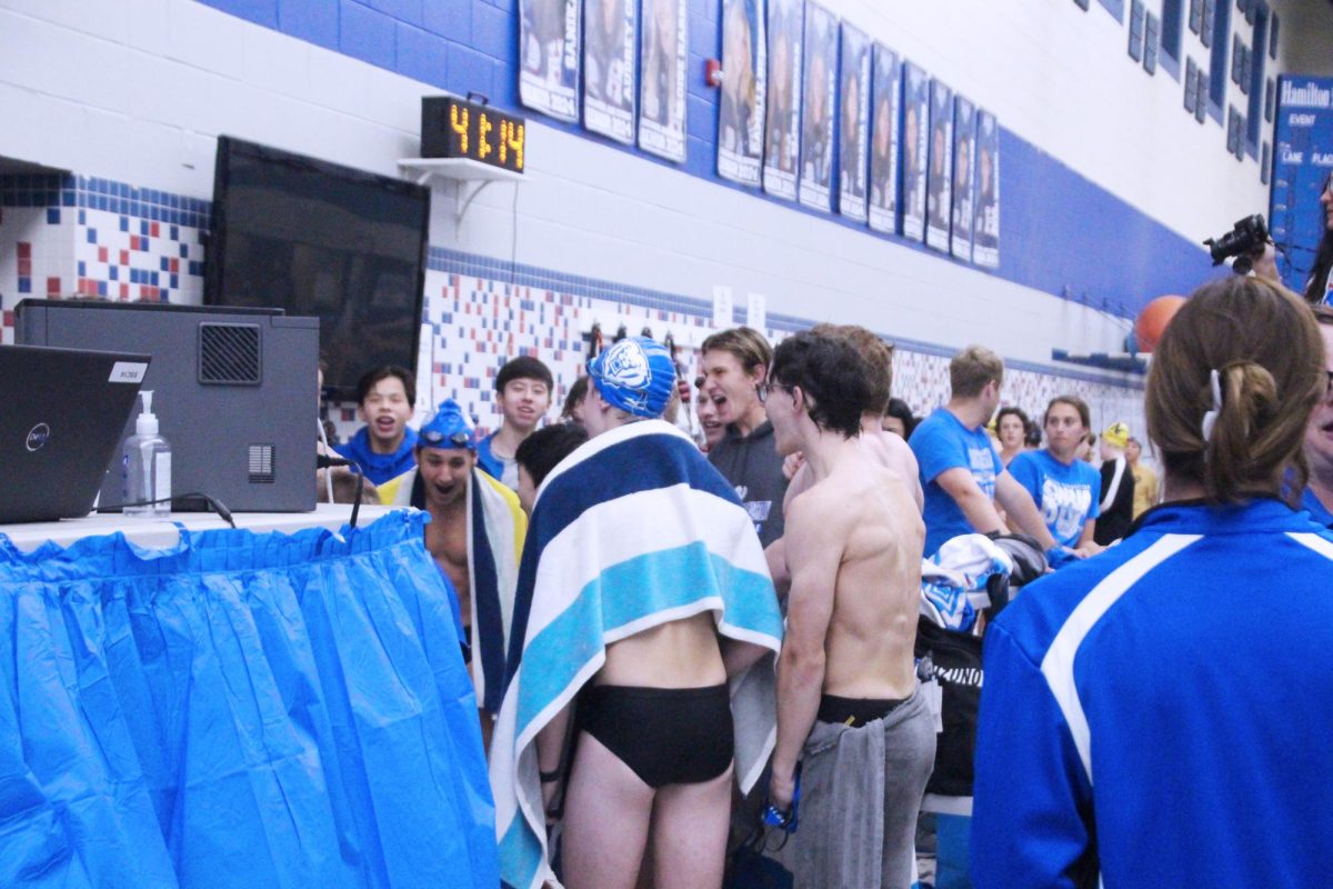 The HSE boys team do their team cheer at the start of the meet. The team celebrates one another before swimming their first dual meet of the season. 