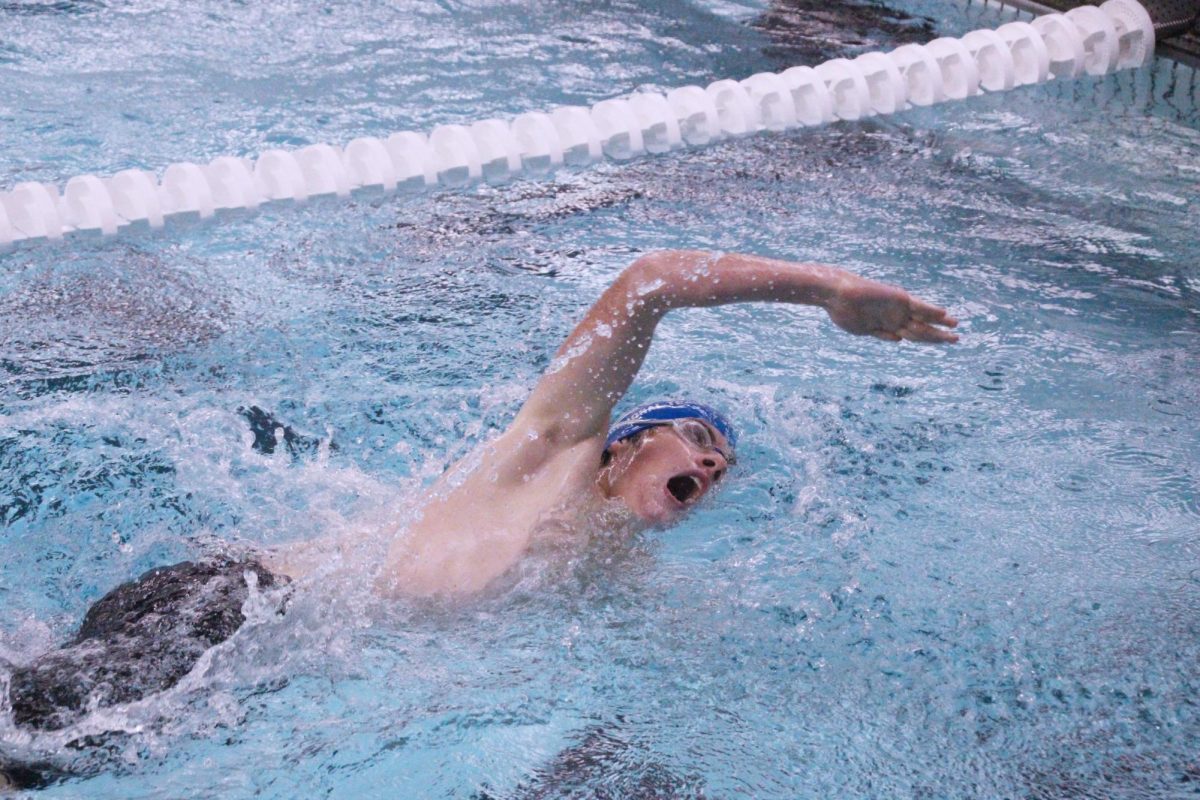 Sophomore Connor Pugh swims freestyle into the wall during his 500 freestyle race. Pugh placed 8th in the event with a time of 6:30.35. 