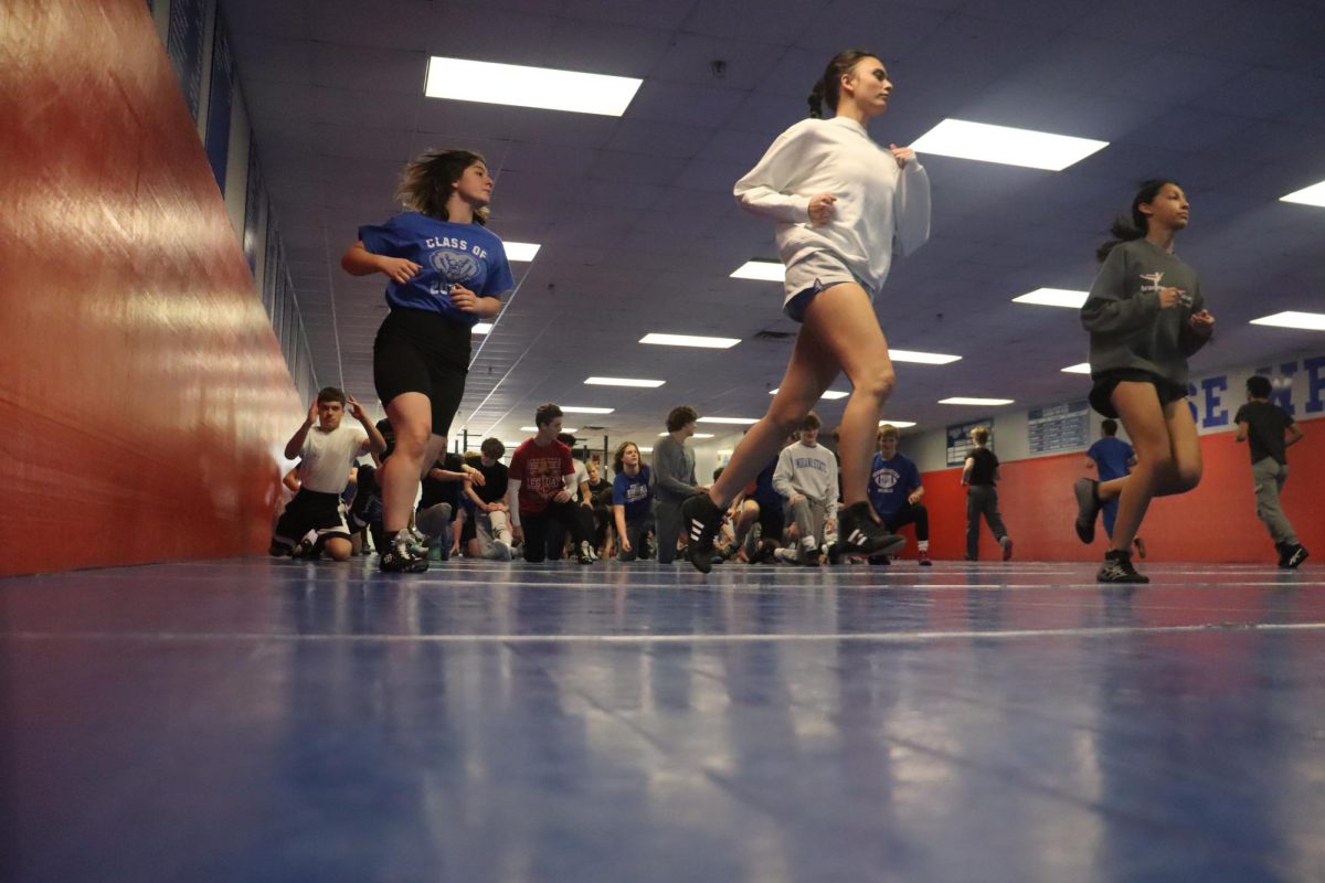 Wrestlers warming up around the mat