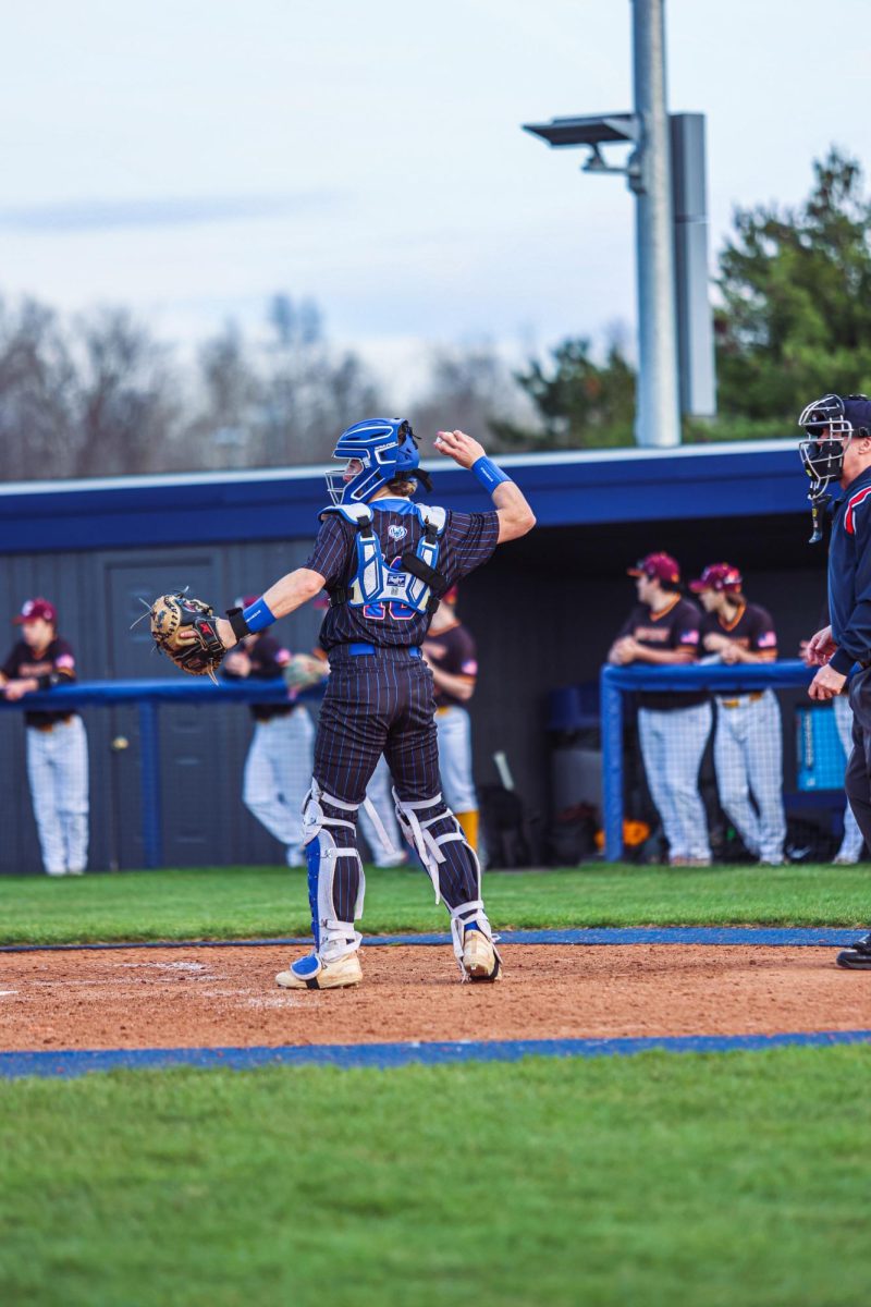 Senior Alex Billman throwing the ball back to his pitcher after catching a fly ball.