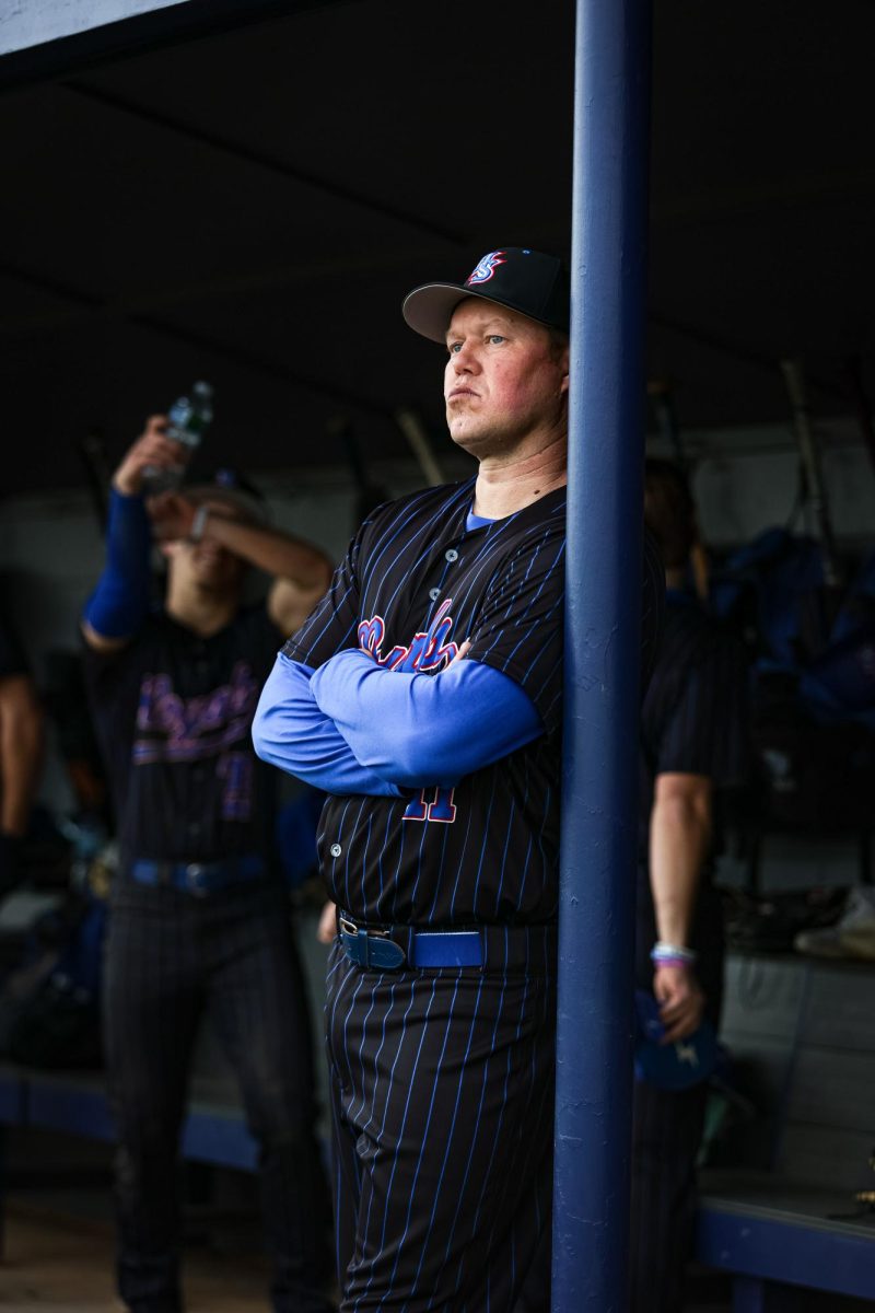 Coach Seitz in the dug out watching his team warm up.