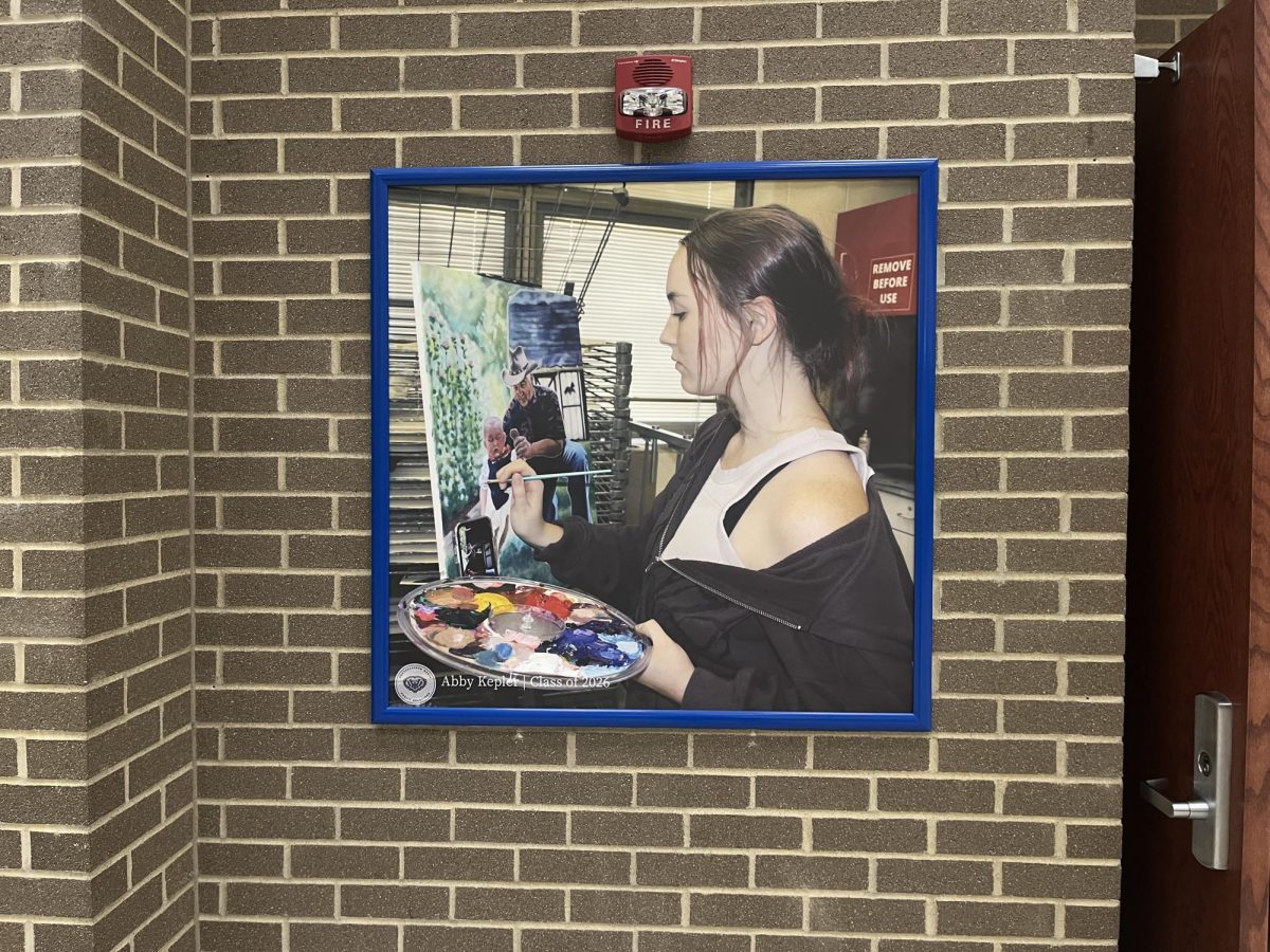 One of the photos put up by Public Relations is located by J140B. This photo showcases Heather Stutz painting, taken by junior Abby Kepler.