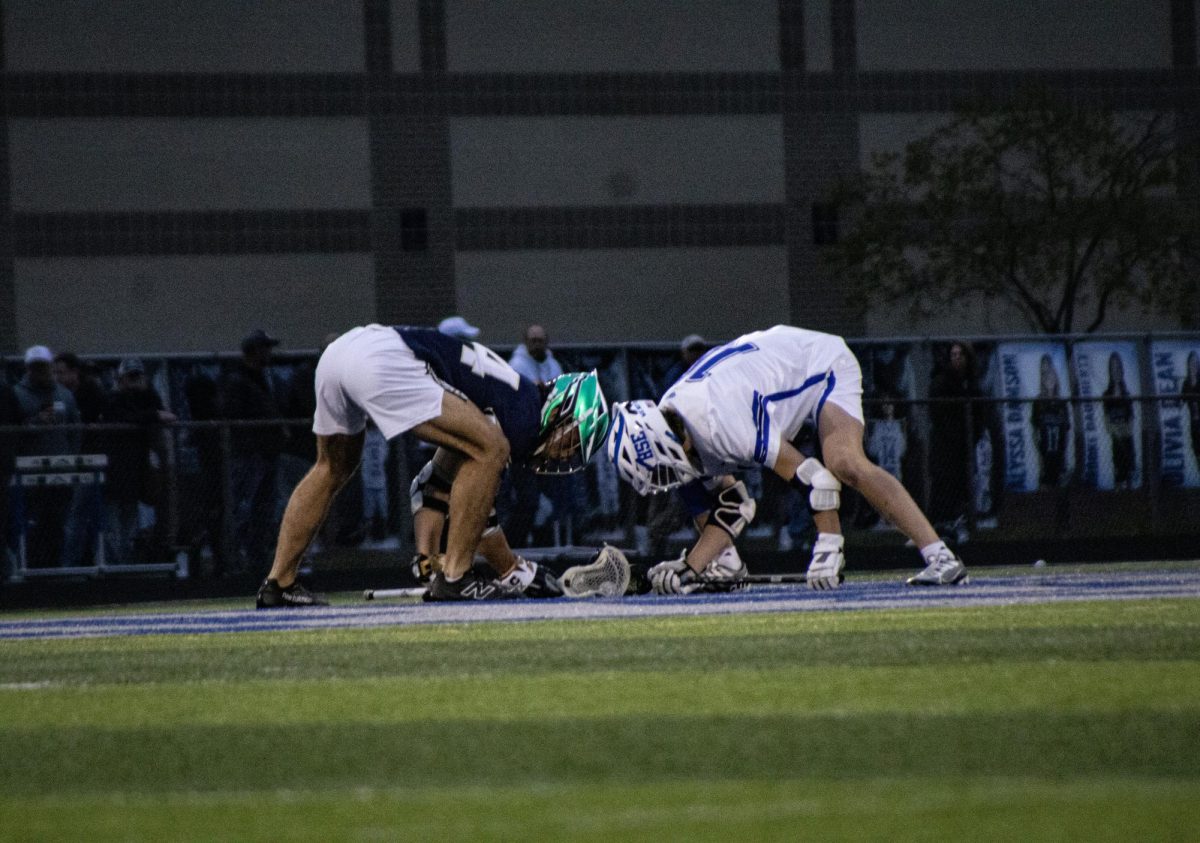 Junior Nick Webber takes face off taking possession 