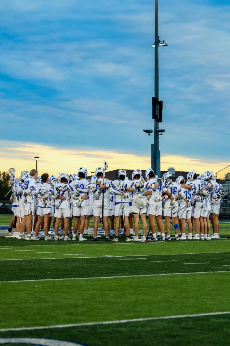 The HSE Boys Varsity Lacrosse team holds each other in unity before the game