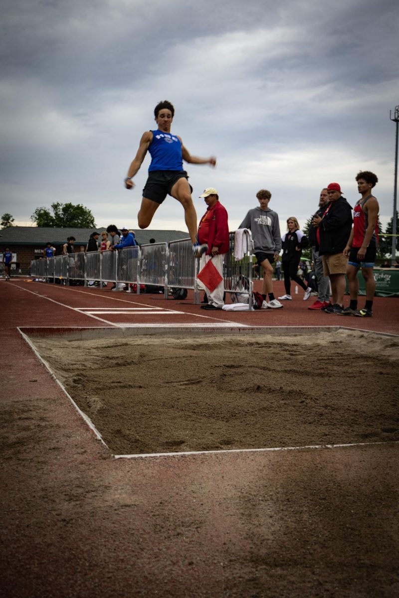 Junior Dylan James completes the long jump 