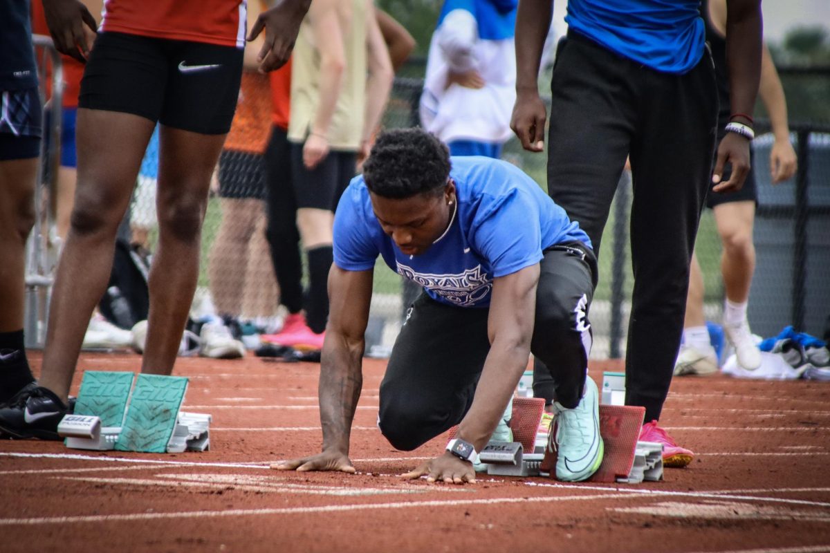 Junior Mason Alexander prepares himself before his 100 meter dash 