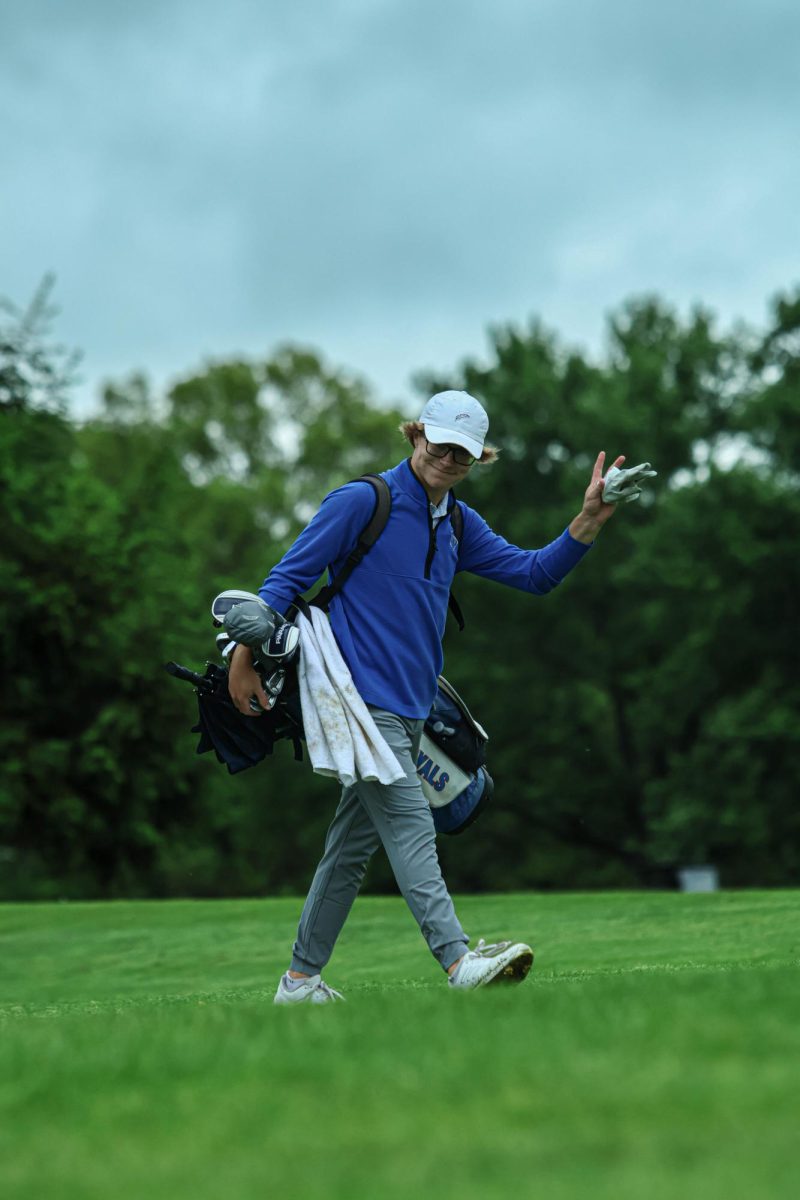 Senior Jordan Huxford waves at Fall Creek Golf Club on May 9th, 2024