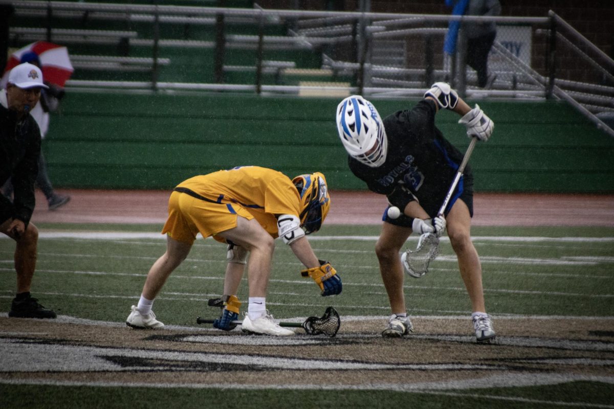 Junior Nick Webber takes face off retrieving ball.