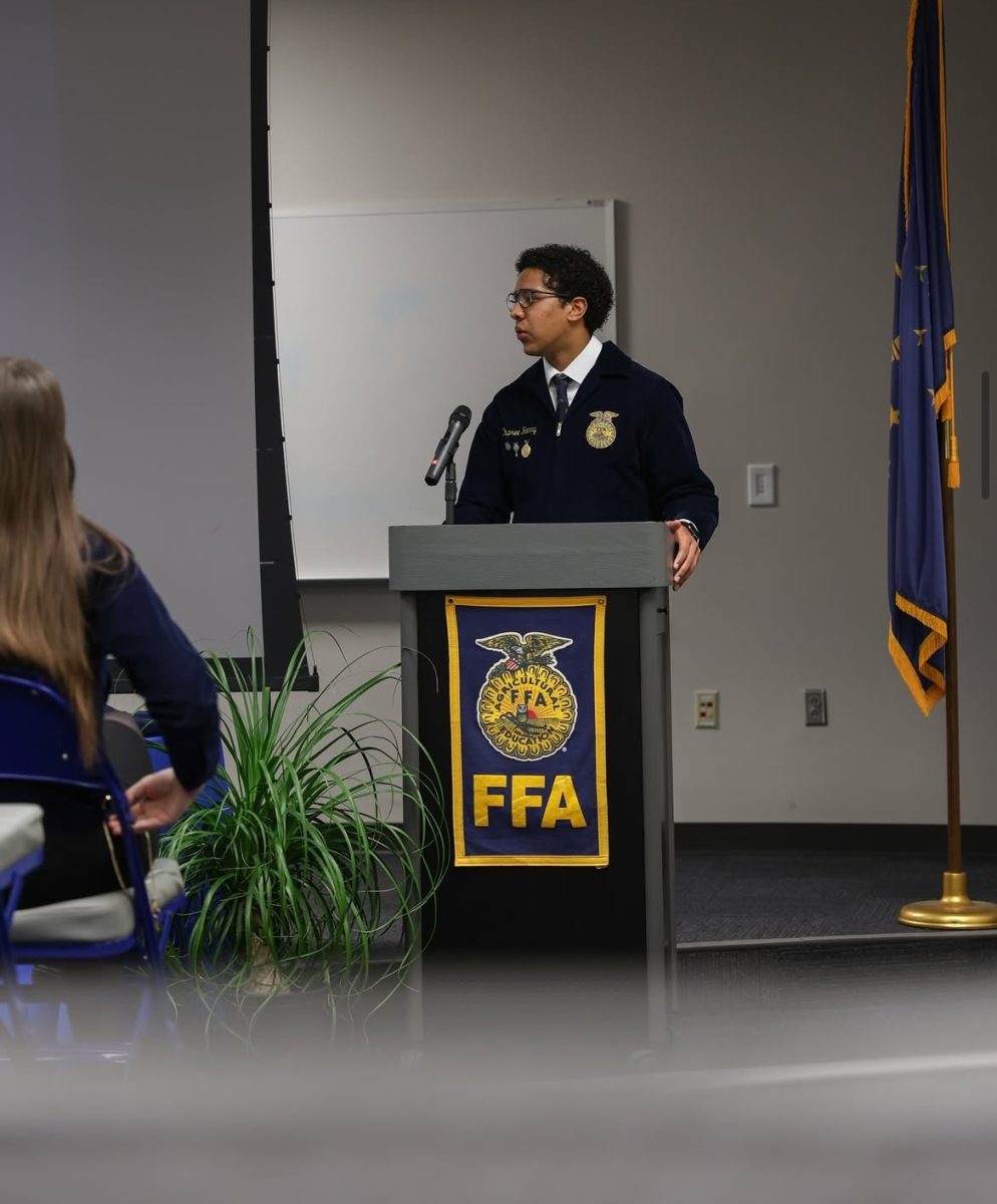 Junior Dupree Henry stands at the podium in front of a room full of FFA members and the Indiana Lieutenant Governor, Micah Beckwith, giving a speech. Beckwith visited HSE to hear about the benefits of agricultural education from the FFA members on February 11th, 2025. 